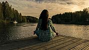 Eine Frau sitz an einem See